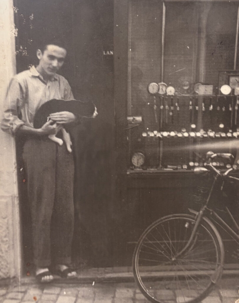 Vecchia foto in bianco e nero, rappresentante Zani Ezio con un gatto in braccio